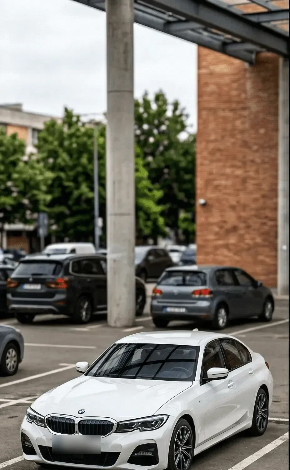 A white BMW 3 Series photographed in a parking lot
