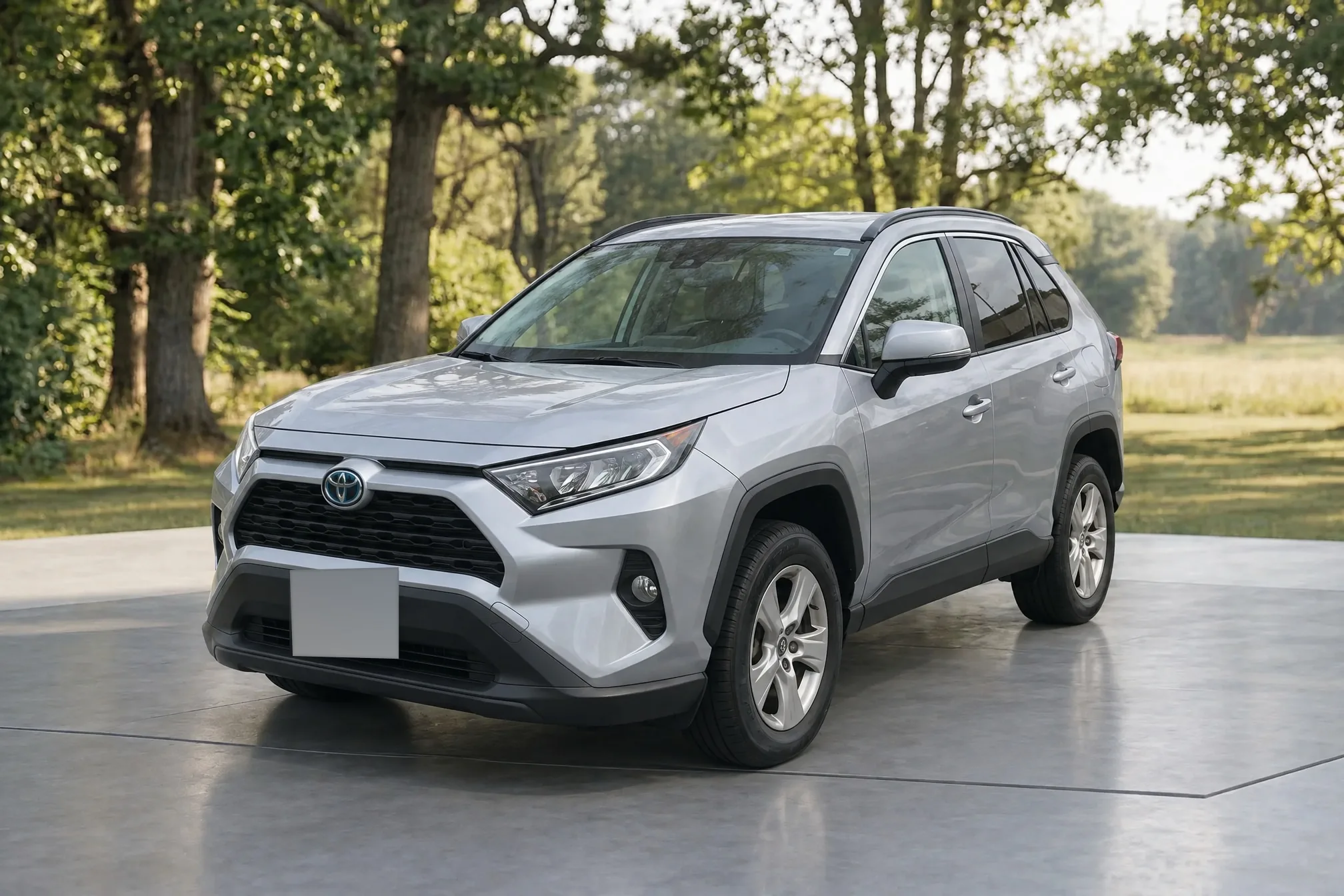 A silver Toyota RAV4 on a stone driveway beside a meadow, finished by Clearcoat